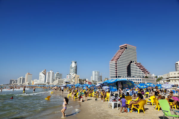 Affluent Israelis relax at the Tel Aviv beach...