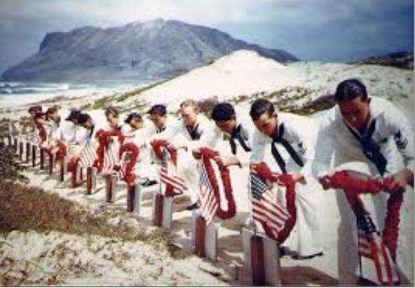 December 8, 1941. American Sailors honor their dea...