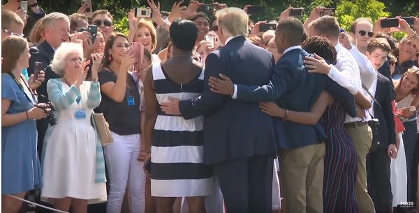 President Trump poses with a black family at WH to...